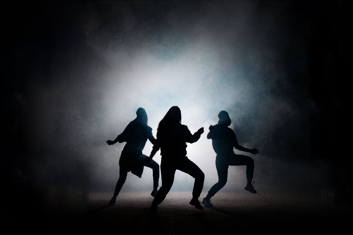 image of dancers backlit on a black background