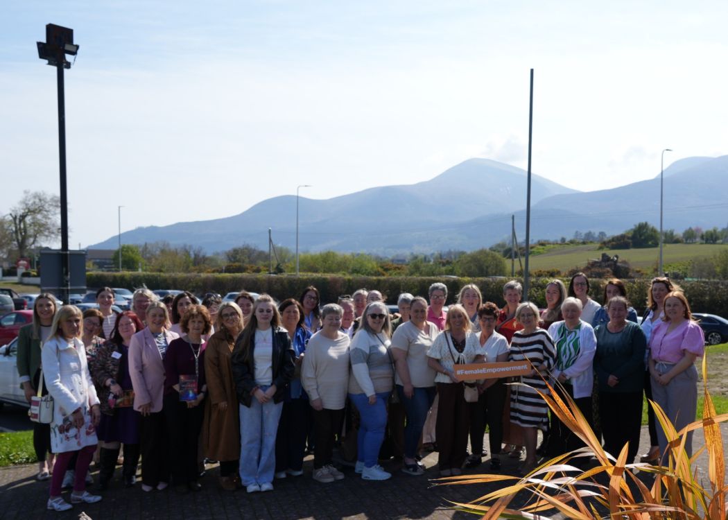 Participants outside the Burrendale in bright sunshine with Mourne Mountains in background.