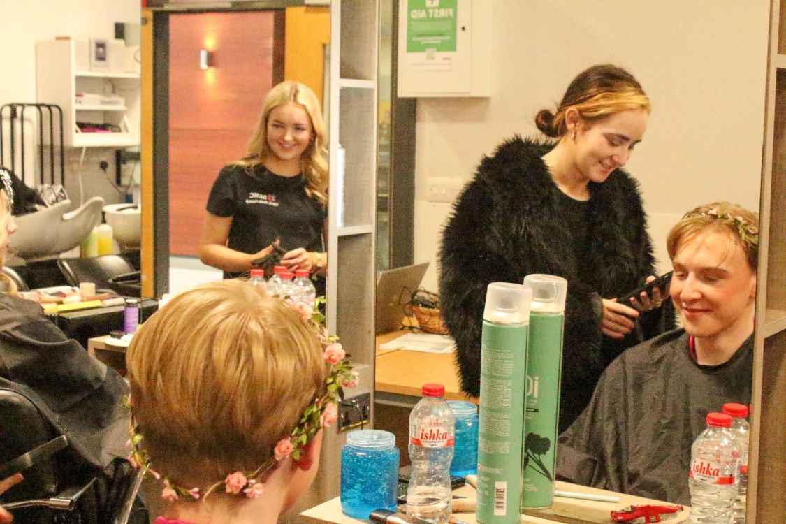 Picture of a hair and media student working on their model