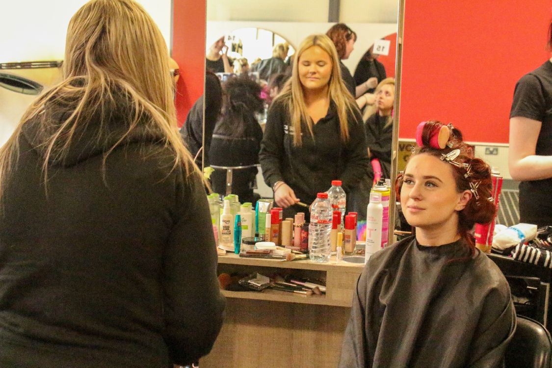 Picture of a hair and media student working on their model