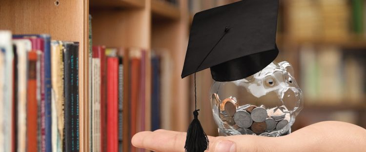Image showing clear piggy bank with money with book background