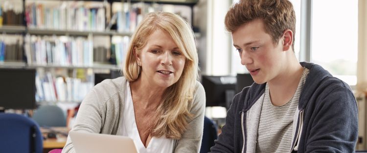 Image showing female staff member and male student in library