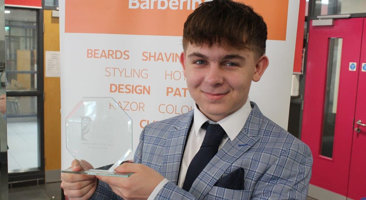 Picture of Owen Andrews holding his Young Barber of the Year award