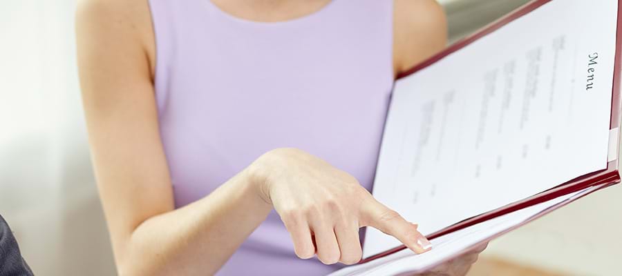 A picture of someone pointing at a menu.